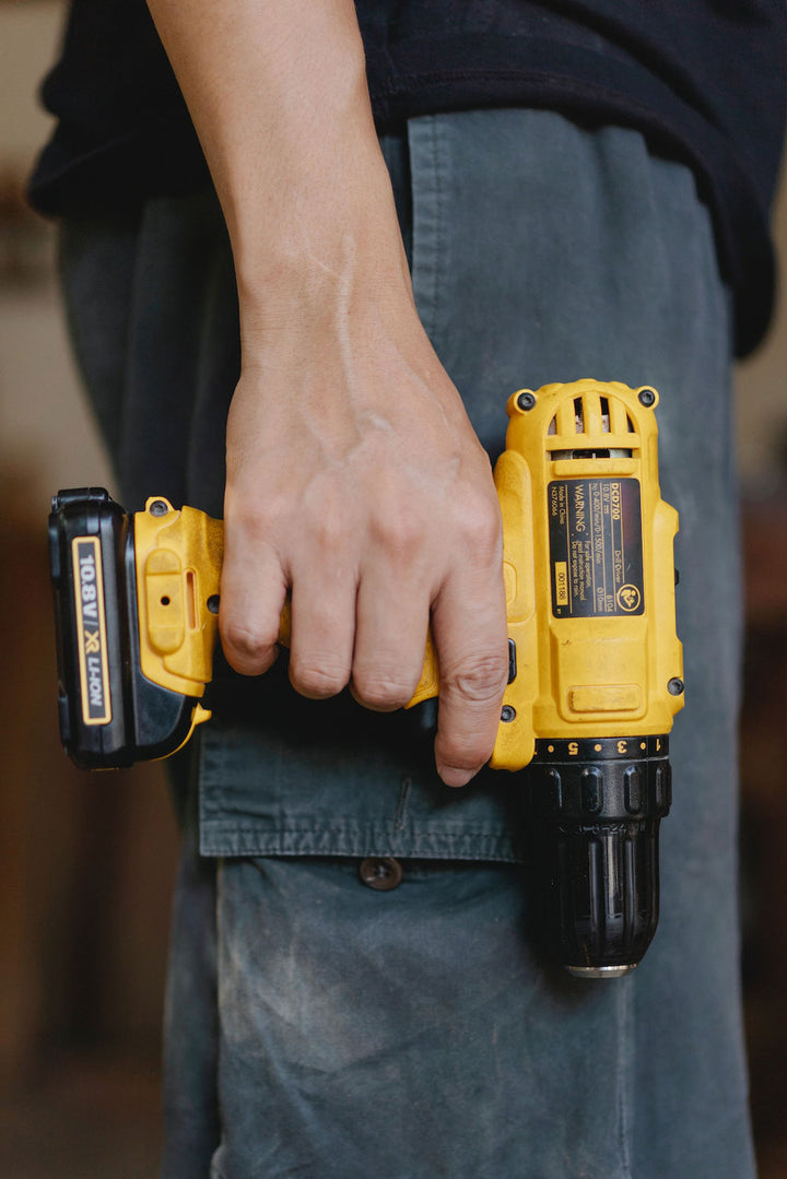 Man holding a yellow screw gun.