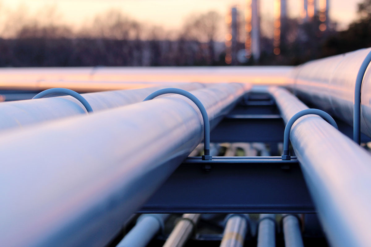 Round U-bolts wrapped around and securing metal pipes to a beam.